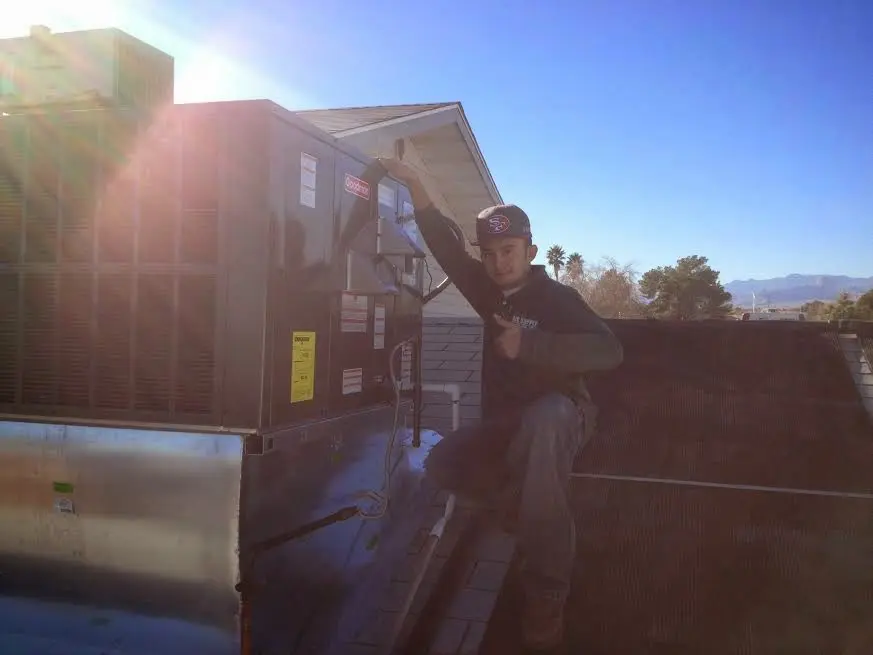 HVAC technician performing HVAC Inspection on a rooftop unit in Alvin